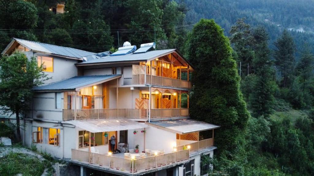 a house on a hill with the lights on at Echor Mountain Crest Jibhi in Jibhi