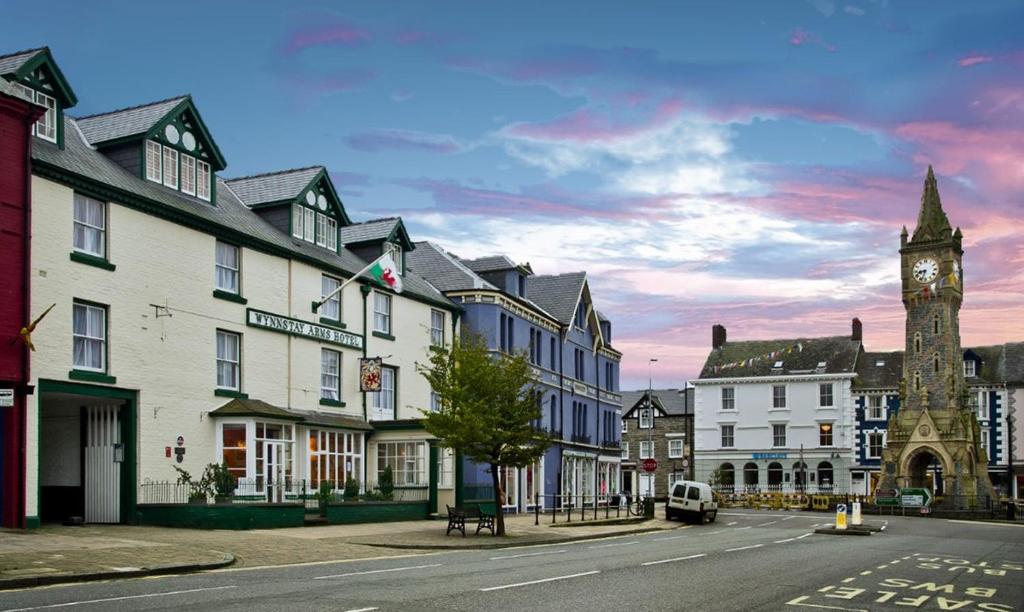 una ciudad con una torre de reloj en medio de una calle en The Wynnstay en Machynlleth