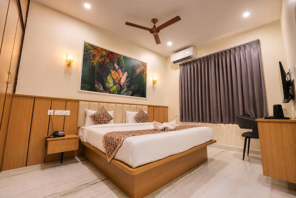 a hotel room with a bed and a television at Hotel SSV Suites Premium Near HItech City, Madhapur in Hyderabad