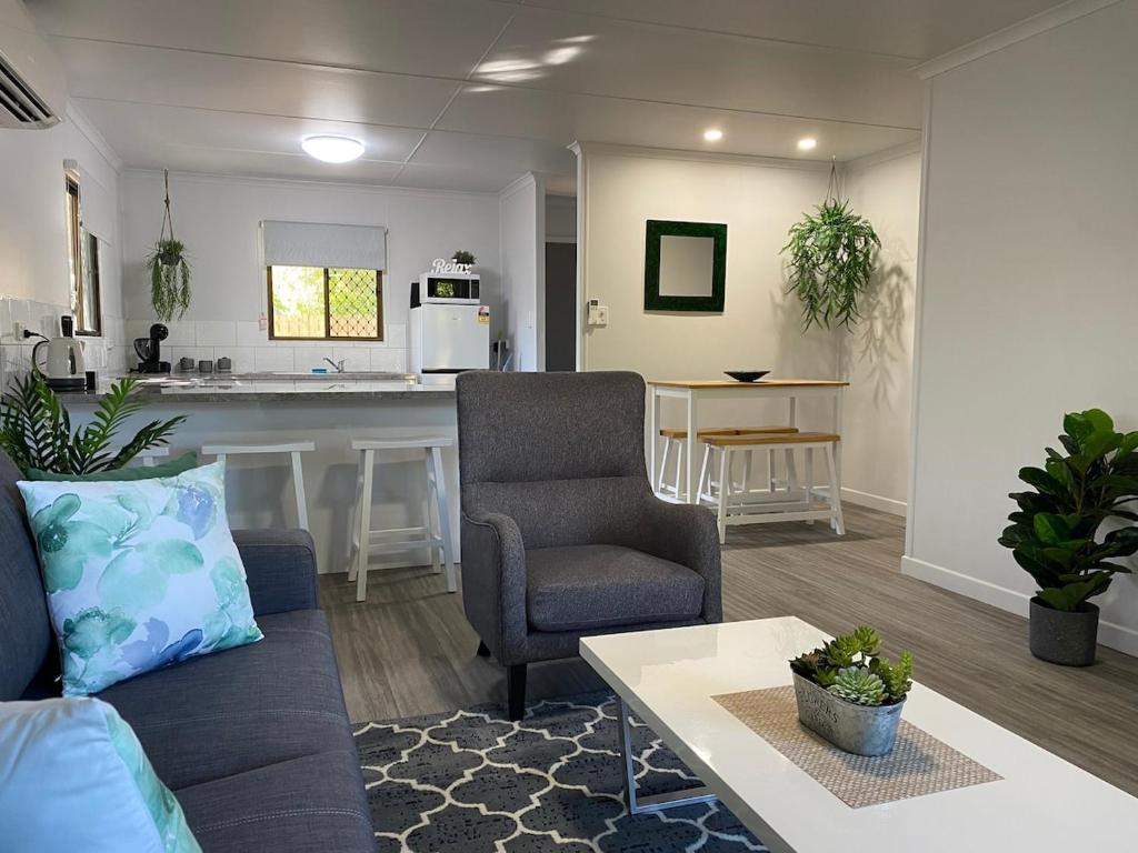 a living room with a couch and a kitchen at Ocean Breezes with Leafy View with Wi-fi in Slade Point