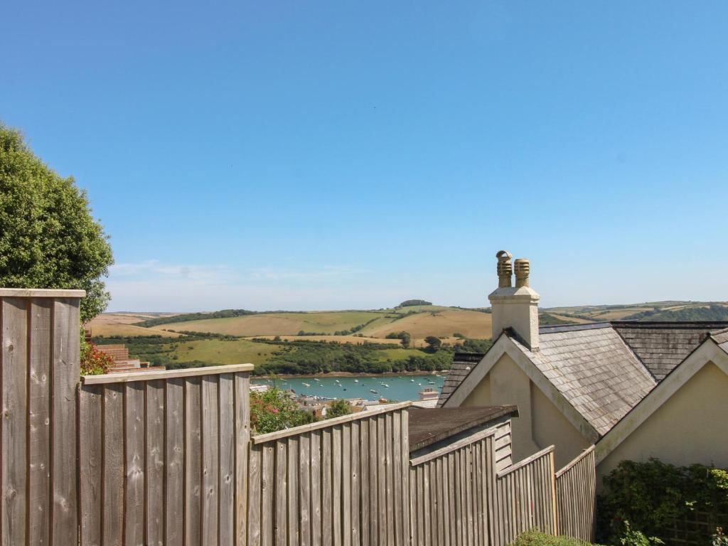 a wooden fence with a view of a river behind it at Waders in Salcombe