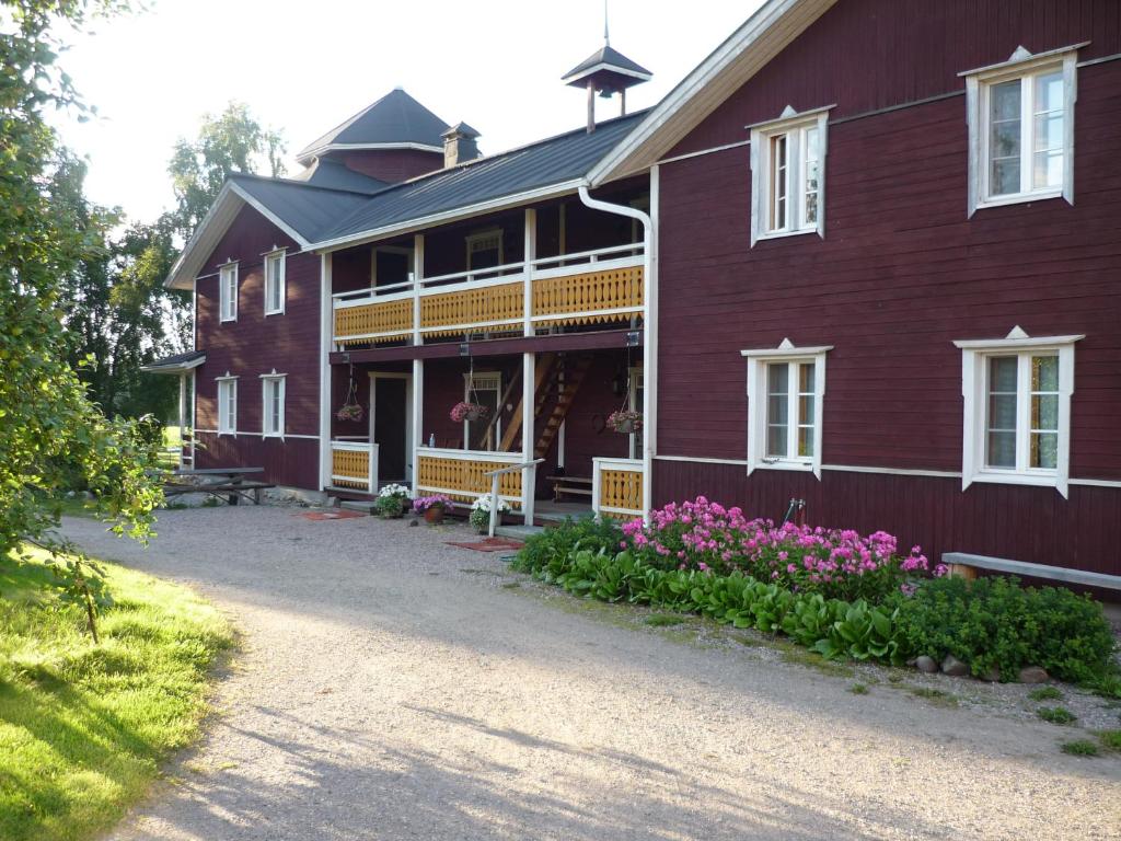 ein rotes Haus mit Blumen davor in der Unterkunft Peltolan Luomutila in Vilppula