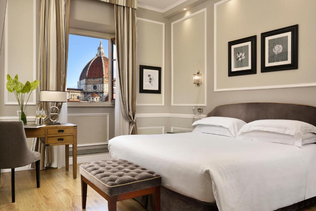 a bedroom with a large white bed and a window at FH55 Hotel Calzaiuoli in Florence