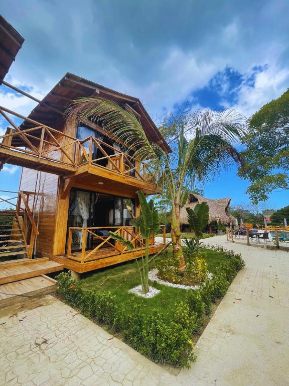 a house with a palm tree in front of it at Oasis Manzanillo Del Mar in Manzanillo del Mar