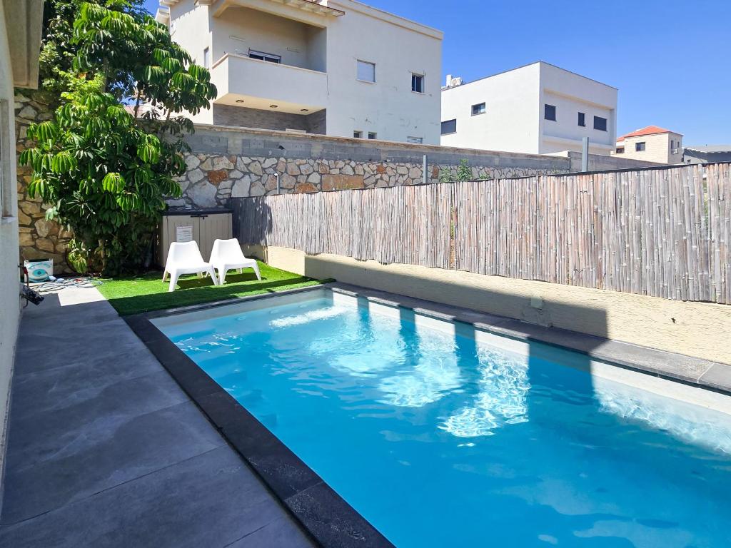a swimming pool in the backyard of a house at המקום של אסי - Assi's place in Oshrat