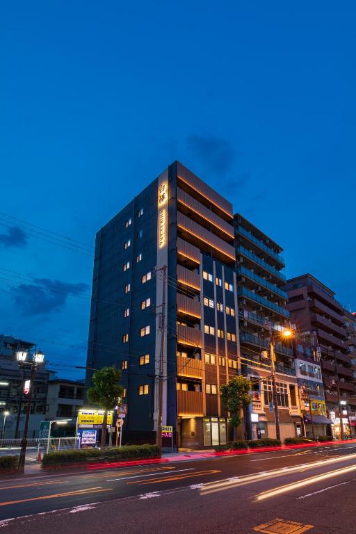 a tall building on a city street at night at 白樺の宿 恵美須, Shirakabanoyado EBISU, SELF CHECK-IN ONLY in Osaka