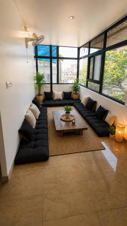 a living room with a large couch and a table at LuxeBnb - Hill View 2bhk Baner in Pune