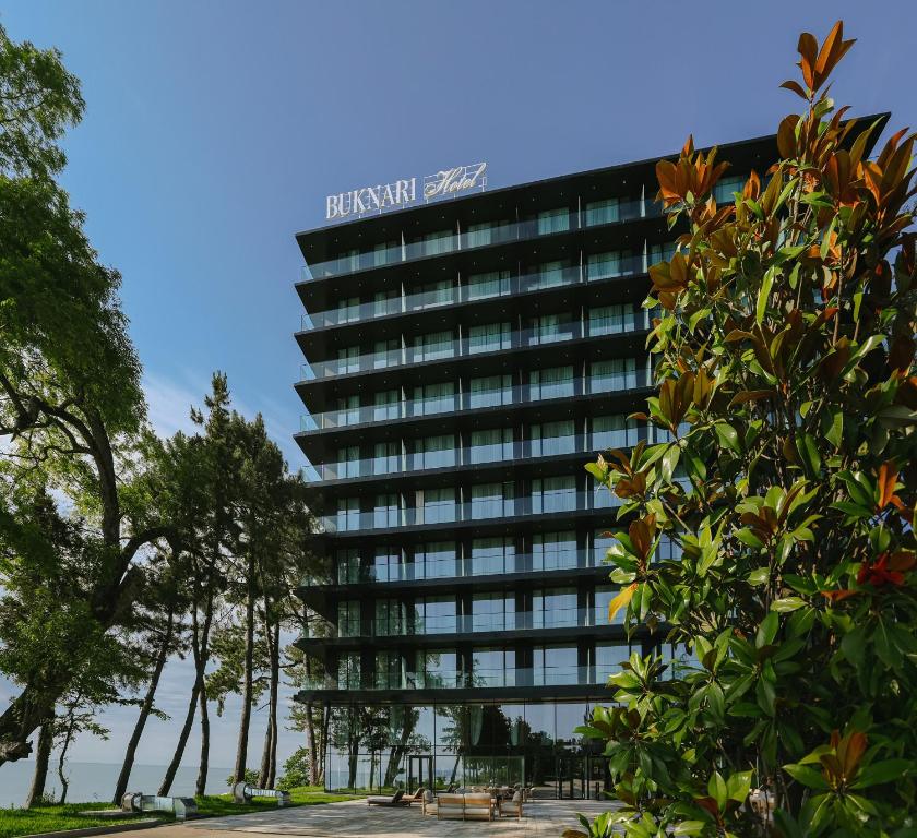 a tall black building with trees in front of it at Buknari Hotel in Buknari