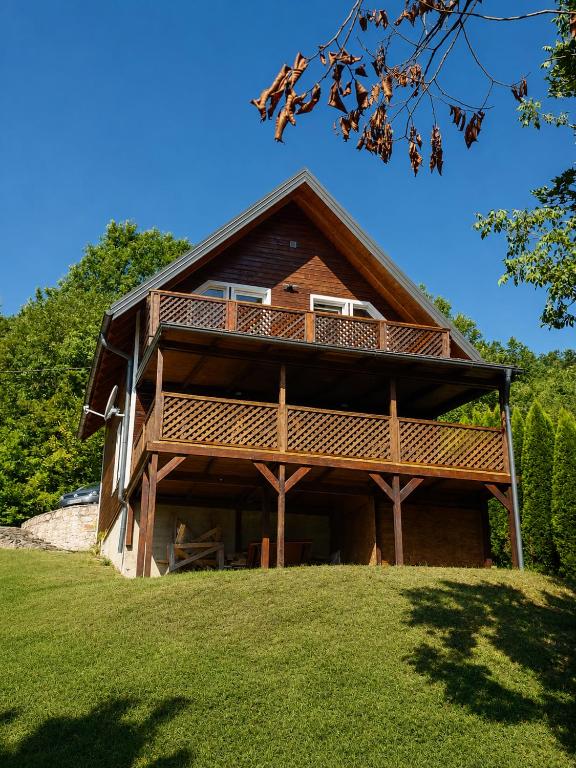 a large wooden house on top of a green field at Holiday Home Alen - Una National Park Retreat - with Garden & Terrace in Kulen Vakuf