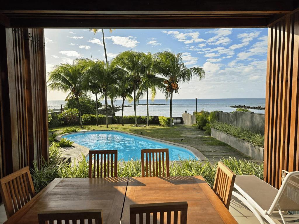 a dining room with a table and a view of the ocean at ReefScape Beachfront Residence in Trou aux Biches