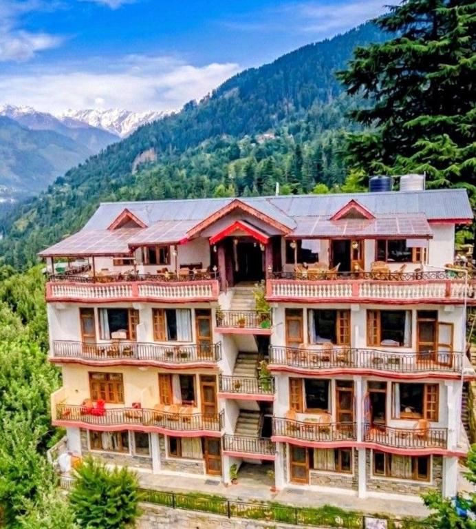 a large building with balconies on top of a mountain at The Kailash Glint in Kalpa