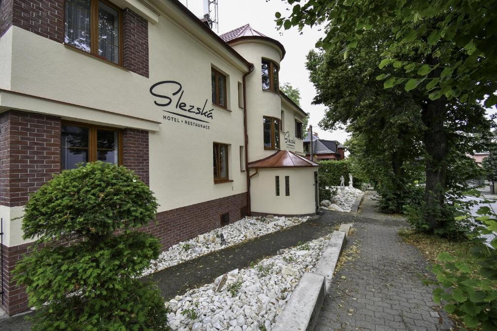 a building with a dog house on the side of it at Hotel Slezská in Muglinov