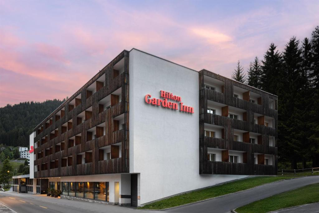 a hotel with a sign on the side of a building at Hilton Garden Inn Davos in Davos