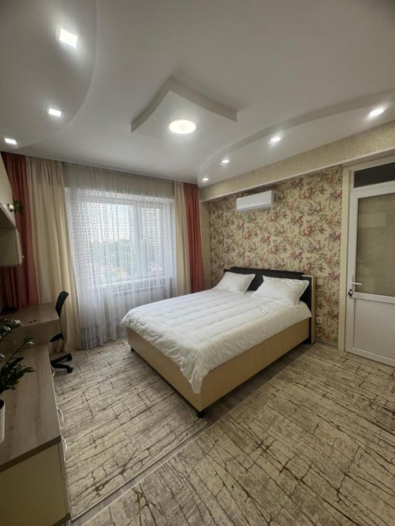 ein Schlafzimmer mit einem großen Bett und einem Fenster in der Unterkunft Flora in Chişinău