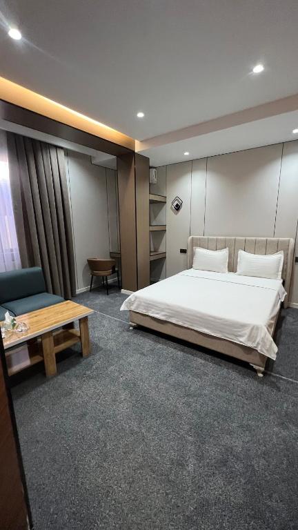 a bedroom with a bed and a couch and a table at Comfort Hotel in Osh
