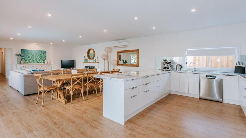 a kitchen and dining room with a table and chairs at Blissful Escape in Portsea