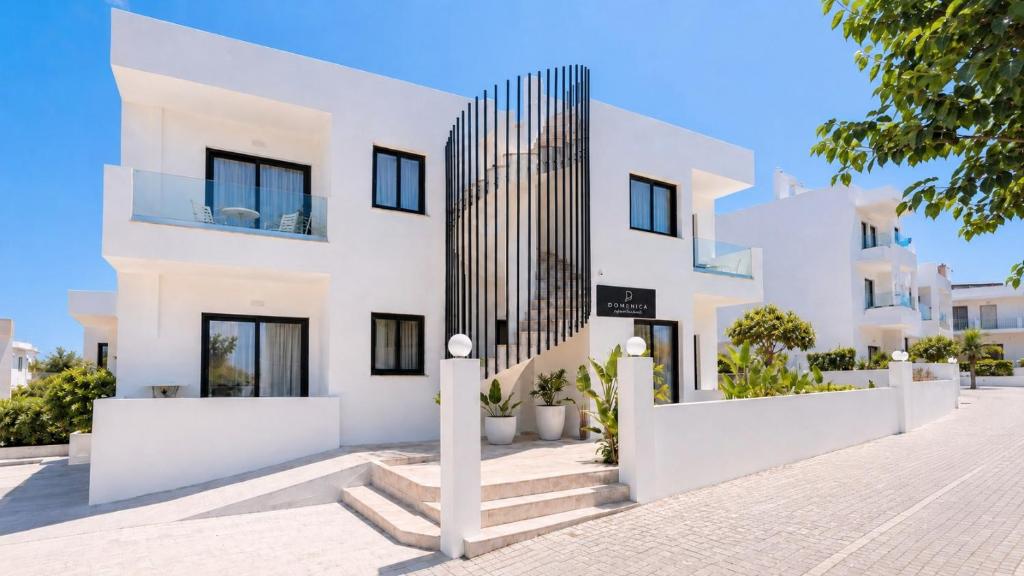 a white house with black windows and stairs at Domenica Apartments in Rethymno