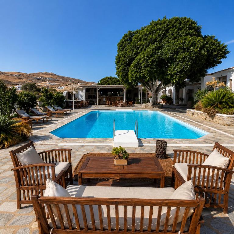 a swimming pool with chairs and a wooden table next to a pool at Paros Poolside Cozy Nests - Summer & Salty Getaways in Kalami