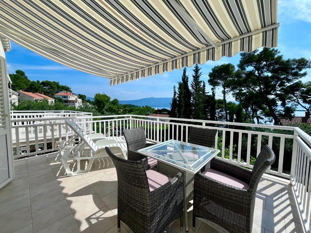 a patio with a table and chairs on a balcony at Villa Joković in Lumbarda