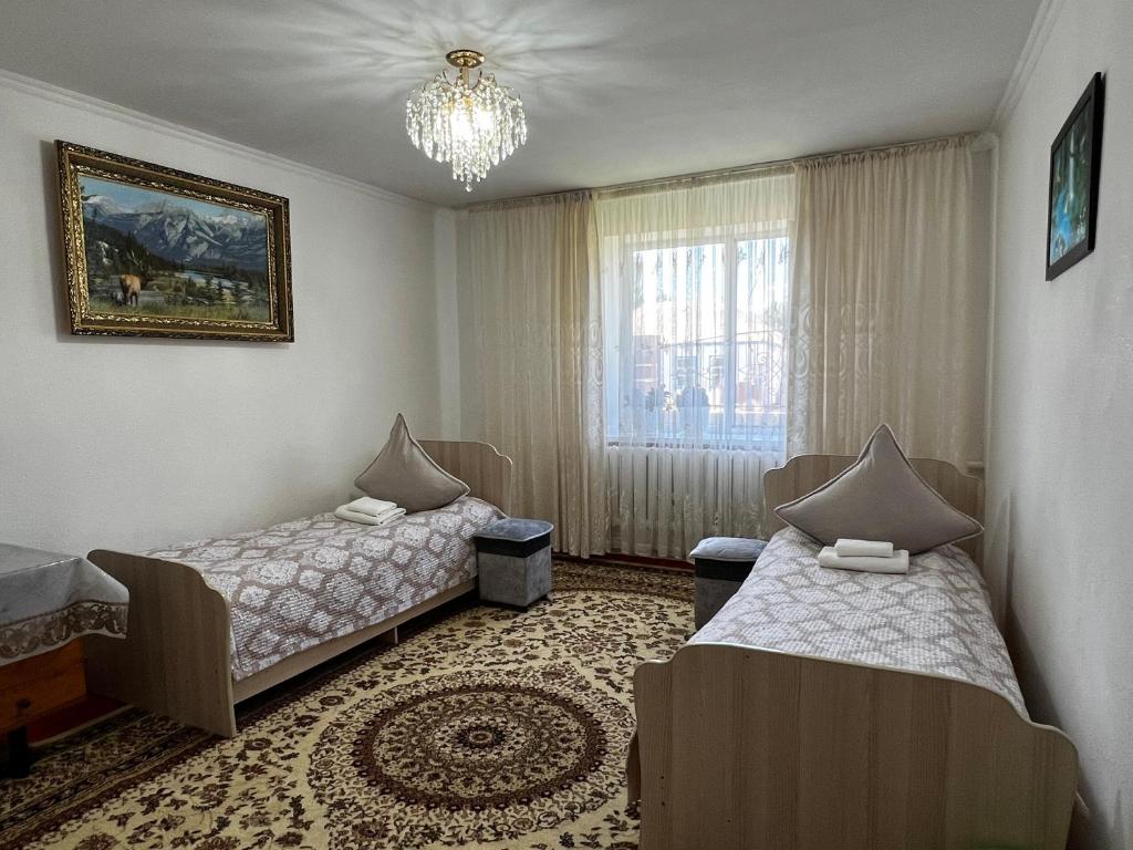 a room with two beds and a chandelier at Sultan in Kochkorka