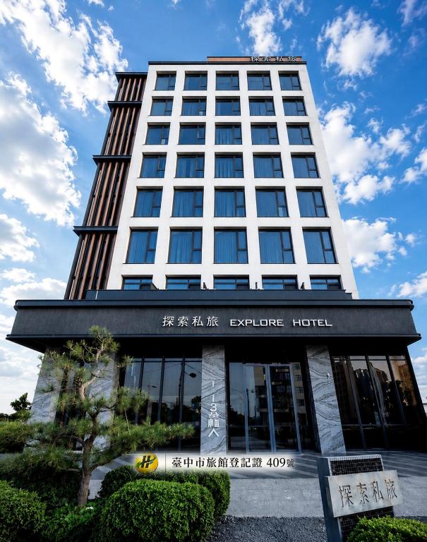 a tall building with a sign in front of it at Explore Hotel in Taichung