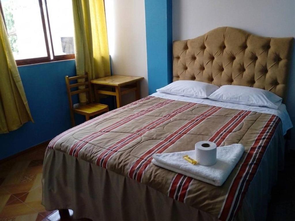 a bed with a blanket and a roll of toilet paper on it at Hospedaje Vista Alegre in Oxapampa