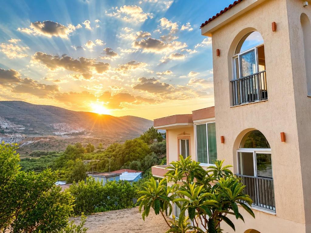 a house with the sunset in the background at Villa Shelegar in (( Metoq ))