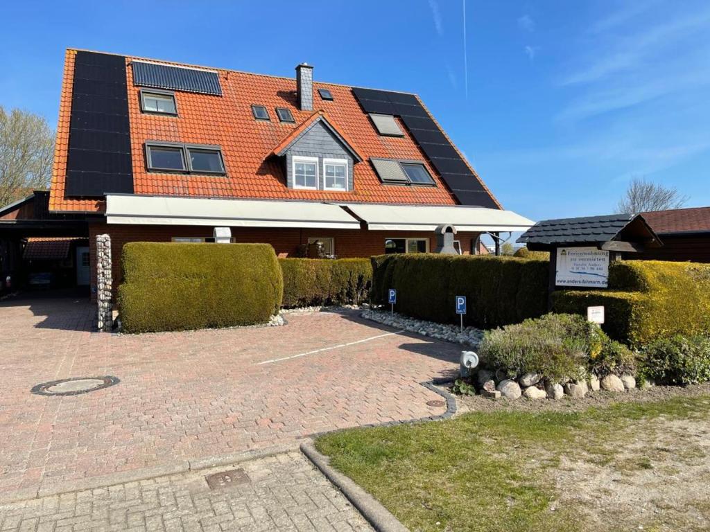a house with an orange roof and a driveway at 10 Ferienwohnung Anders Fewo 1 in Burg auf Fehmarn