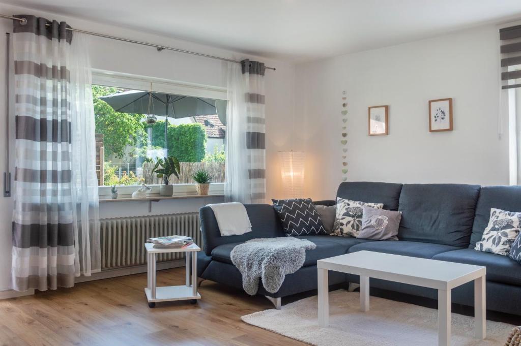 a living room with a blue couch and a table at Ferienwohnung Dorfliebe in Gerolfingen