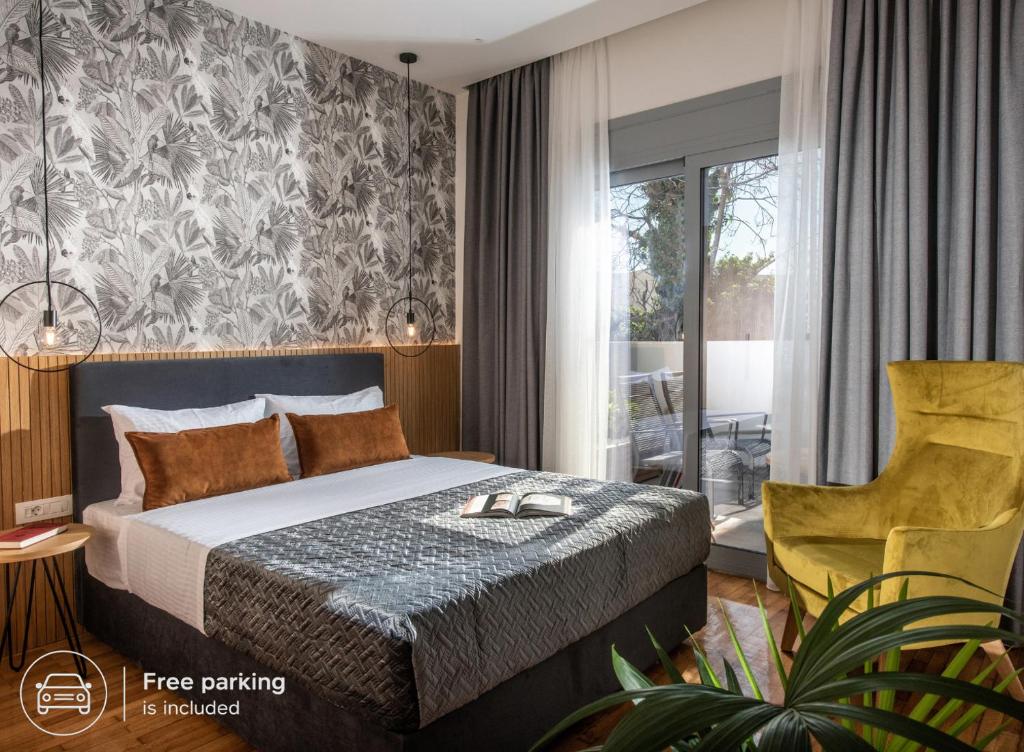 a hotel room with a bed and a chair at Kipos Boutique Suites in Heraklio