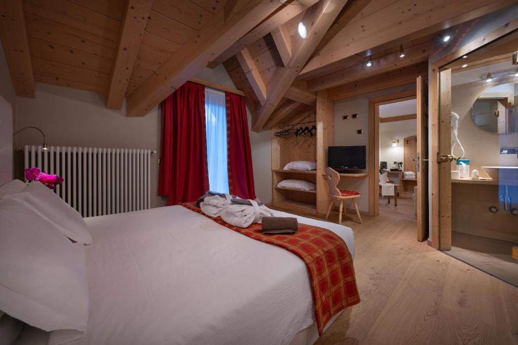 a bedroom with a large white bed in a room at Hotel Cristallo in Livigno