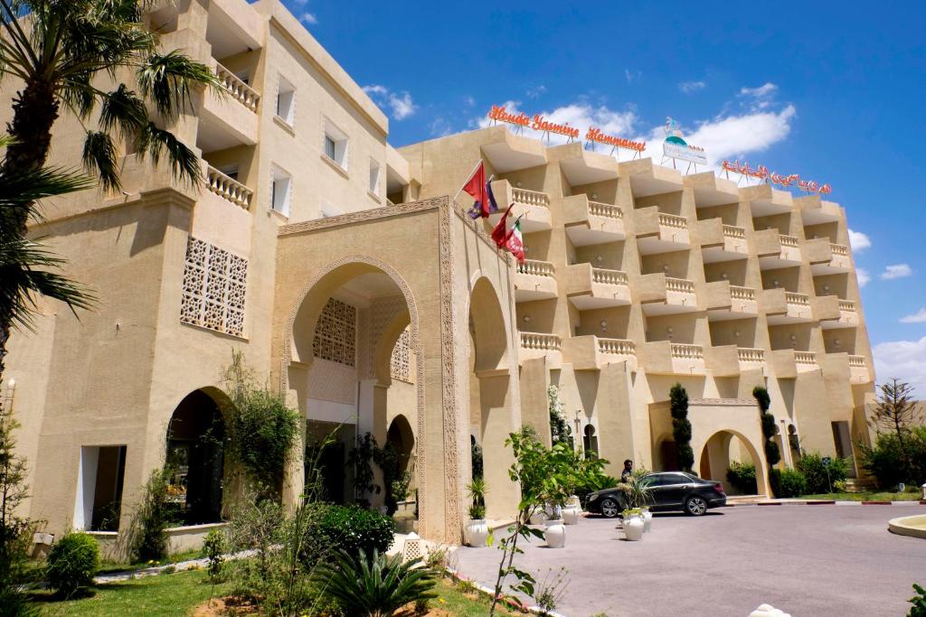 een gebouw waar een auto voor geparkeerd staat bij Houda Yasmine Marina & SPA in Hammamet