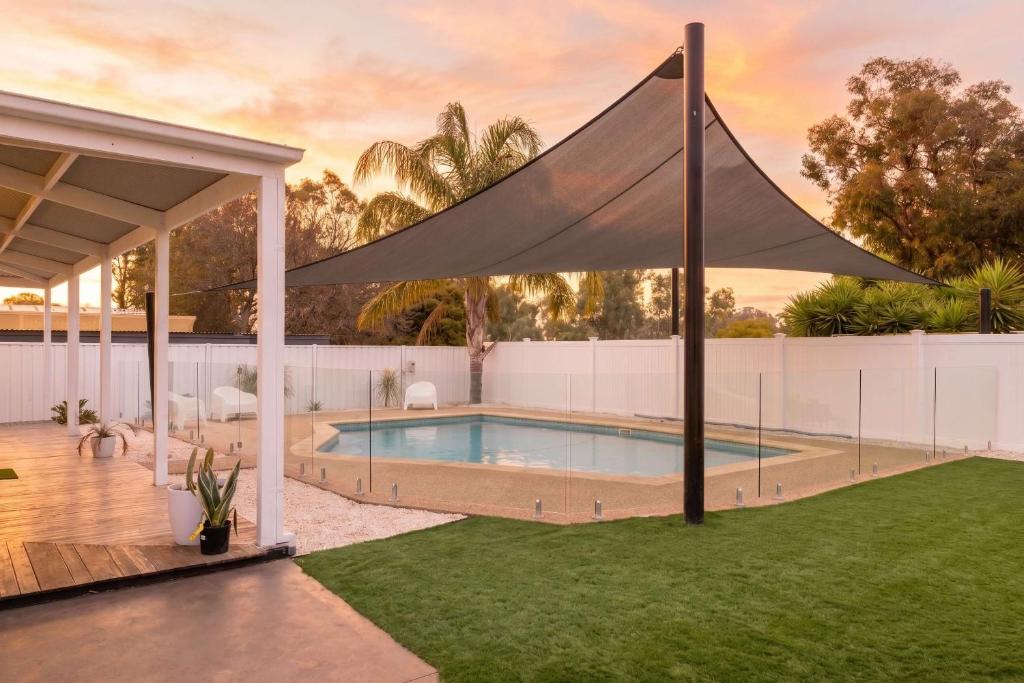 a swimming pool with a canopy in a backyard at Yarra Palms in Yarrawonga