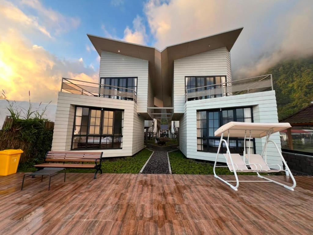 a house with two chairs sitting on a deck at Beji Bedugul Glamping in Bedugul