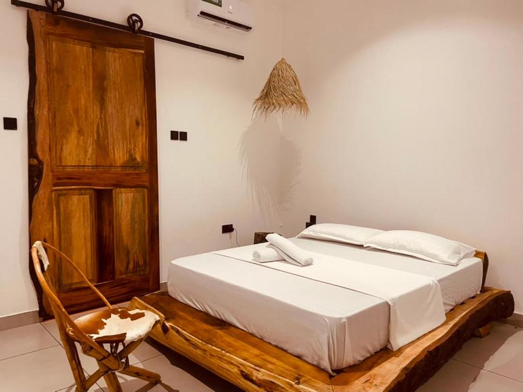 a bedroom with a bed and a wooden door at Maison Studio indépendante in Nungwi