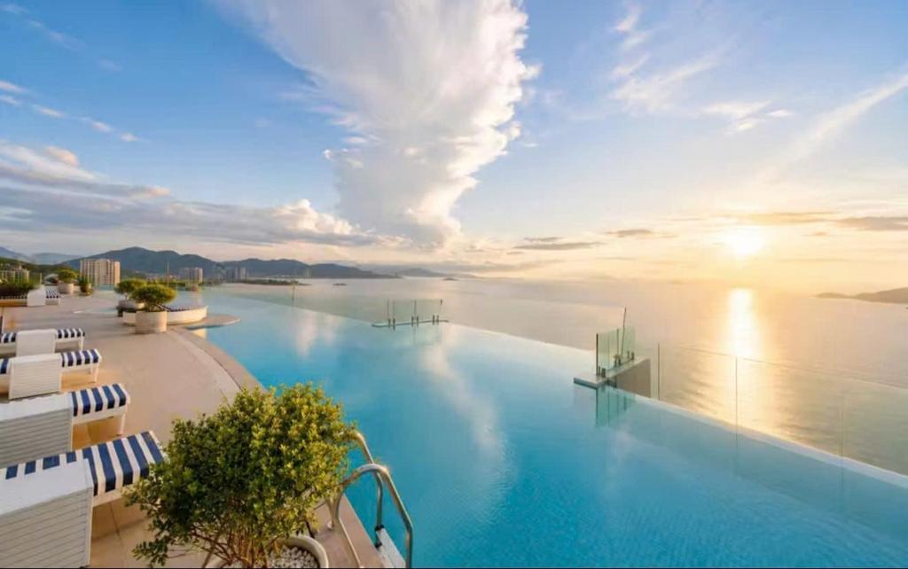 a large swimming pool with a view of the water at Ocean Win Panorama Nha Trang in Nha Trang