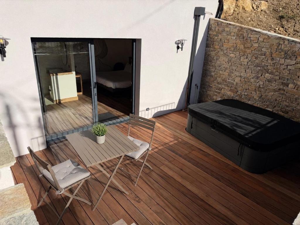 a balcony with a couch and a table and a chair at L'évasion in Saint-Jean-dʼArvey