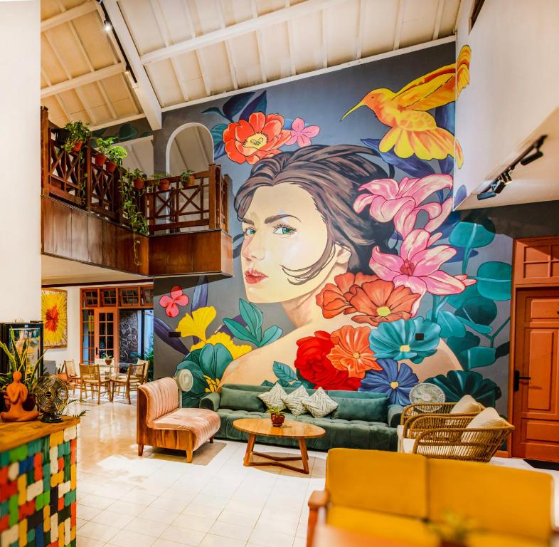 a mural of a woman on a wall in a living room at Huma Yogyakarta Hostel in Yogyakarta