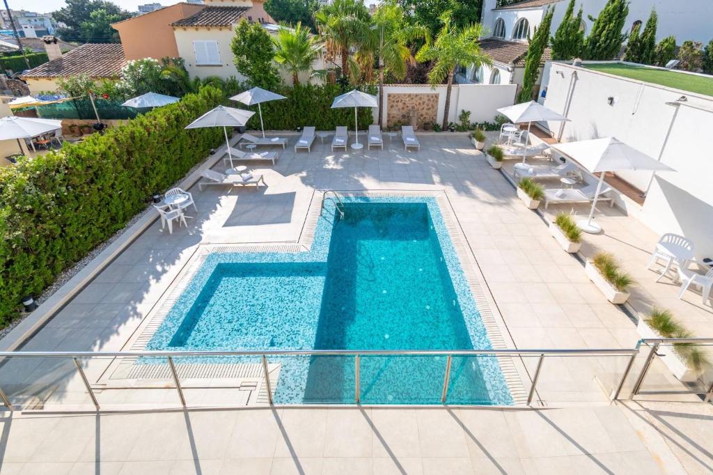 an overhead view of a swimming pool with chairs and umbrellas at Apartamento las palmeras 2 Planta 3 in Cala Millor