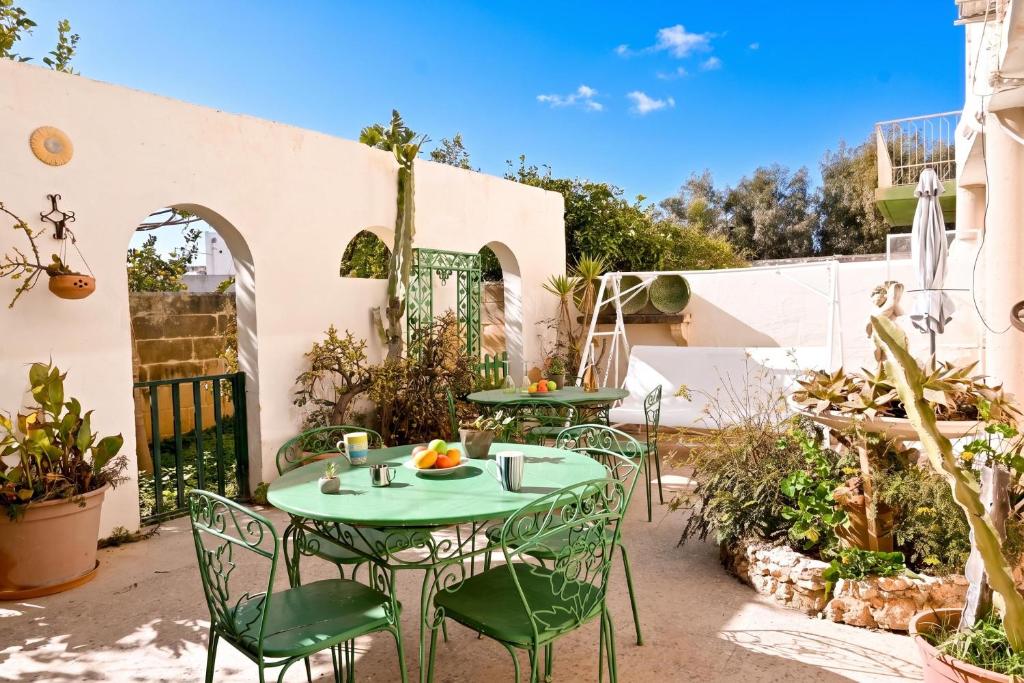 a patio with a table and chairs in a yard at Sefranda Guesthouse in San Ġwann