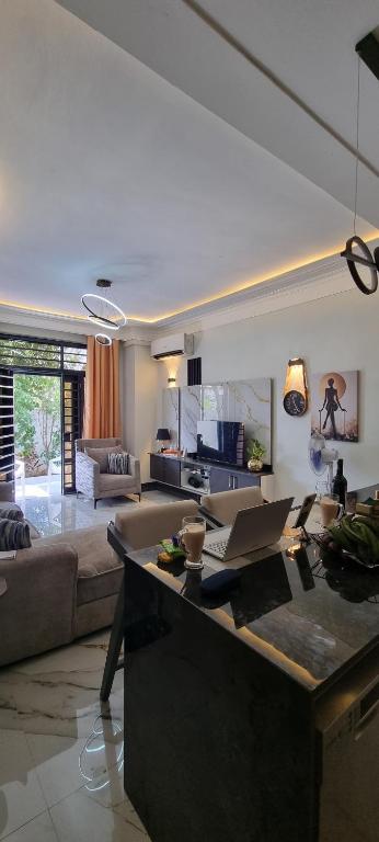 a living room with a couch and a table with a laptop at Legacy Homes in Dar es Salaam