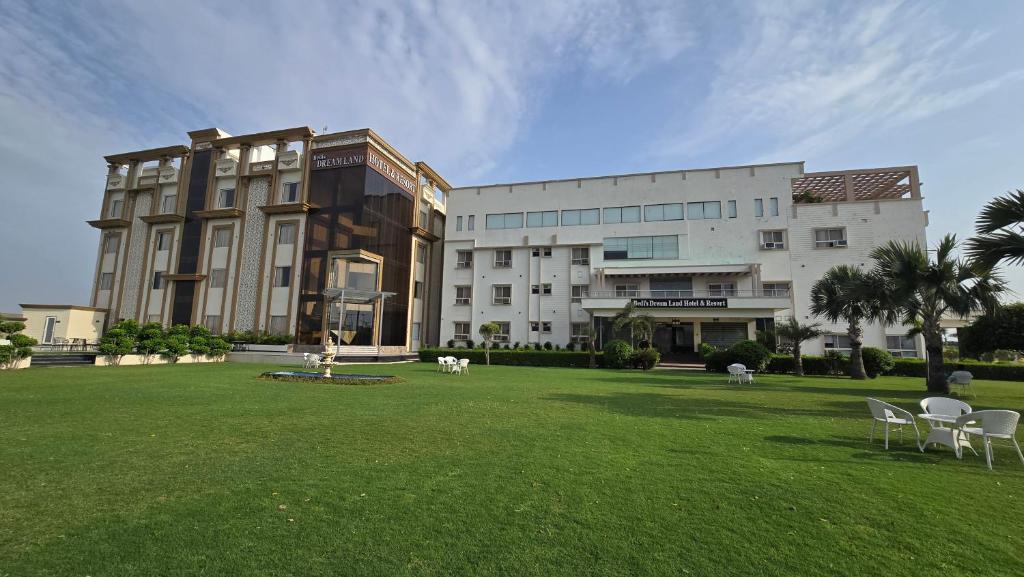 a large building with chairs in the grass in front of it at Bedi's Dream Land Hotel & Resort in Ayodhya