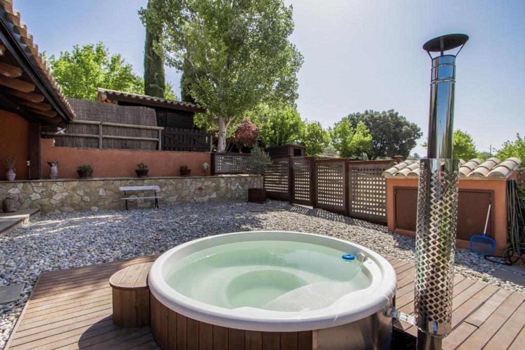 a hot tub on a deck in a yard at Nuestro Antiguo Pajar in Solsona