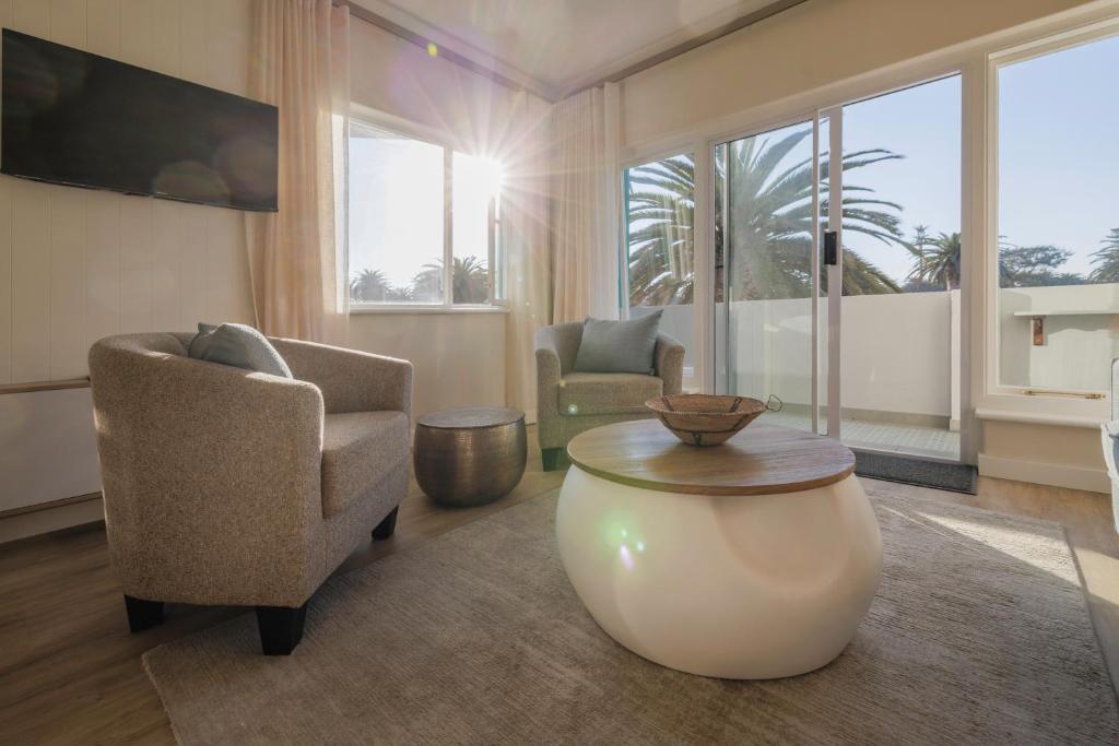 a living room with a chair and a table at Elegant Seaview Suite 1 in Swakopmund