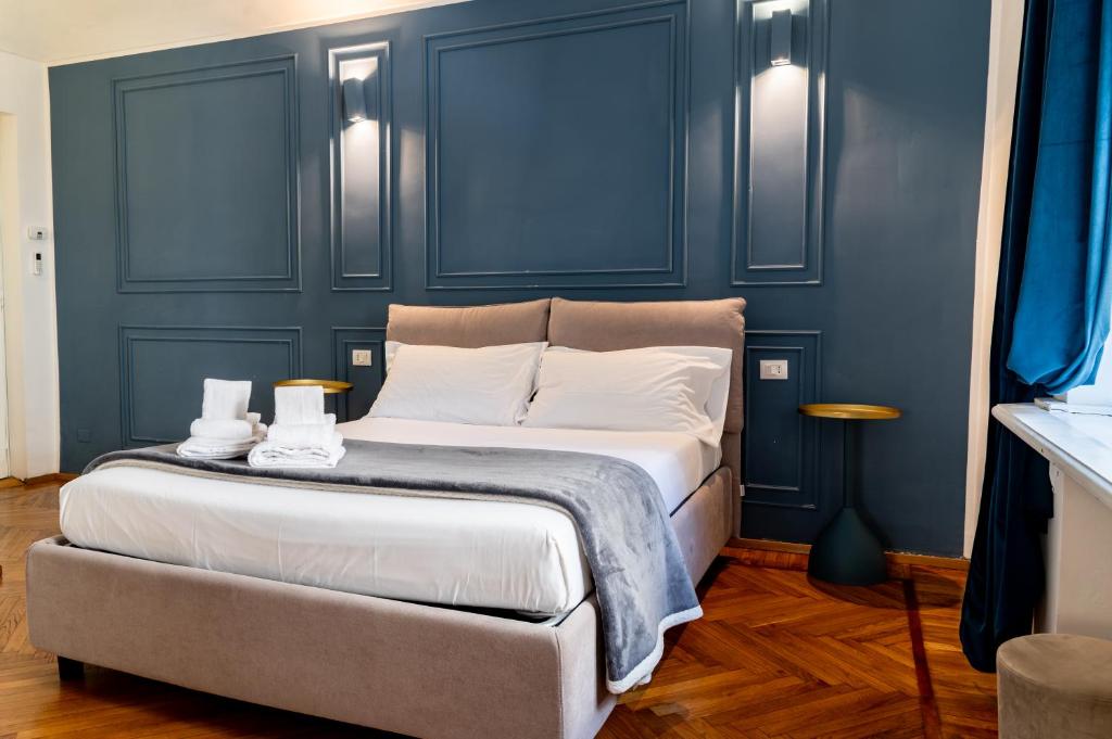 a bedroom with a large bed with blue walls at Turin Central Suite in Turin