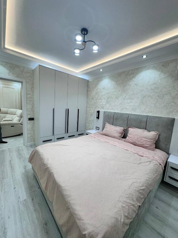a bedroom with a large bed with pink sheets at Apartment Samarkand in Samarkand