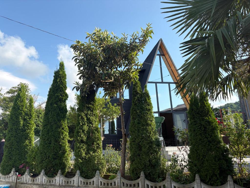 a house with trees in front of a fence at CottageNEO in Charnali