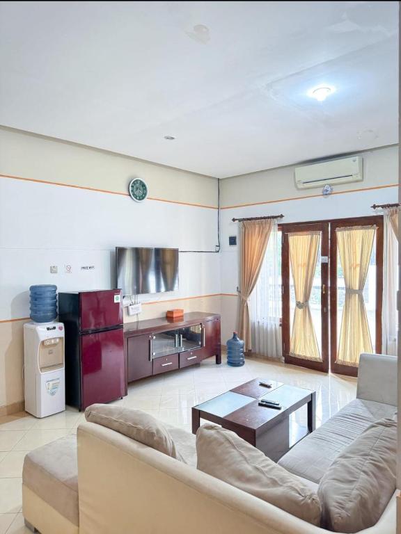 a living room with a couch and a table at Adiputra Guesthouse Tata Bumi by HomiQ in Yogyakarta