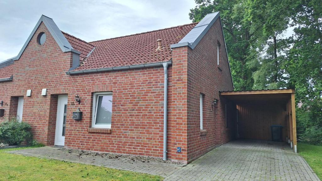 a red brick building with a large garage at Loft Hesel, 35232 in Hesel