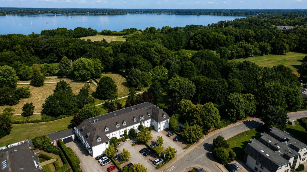 an aerial view of a building next to a lake at NordWest-Hotel Bad Zwischenahn in Bad Zwischenahn